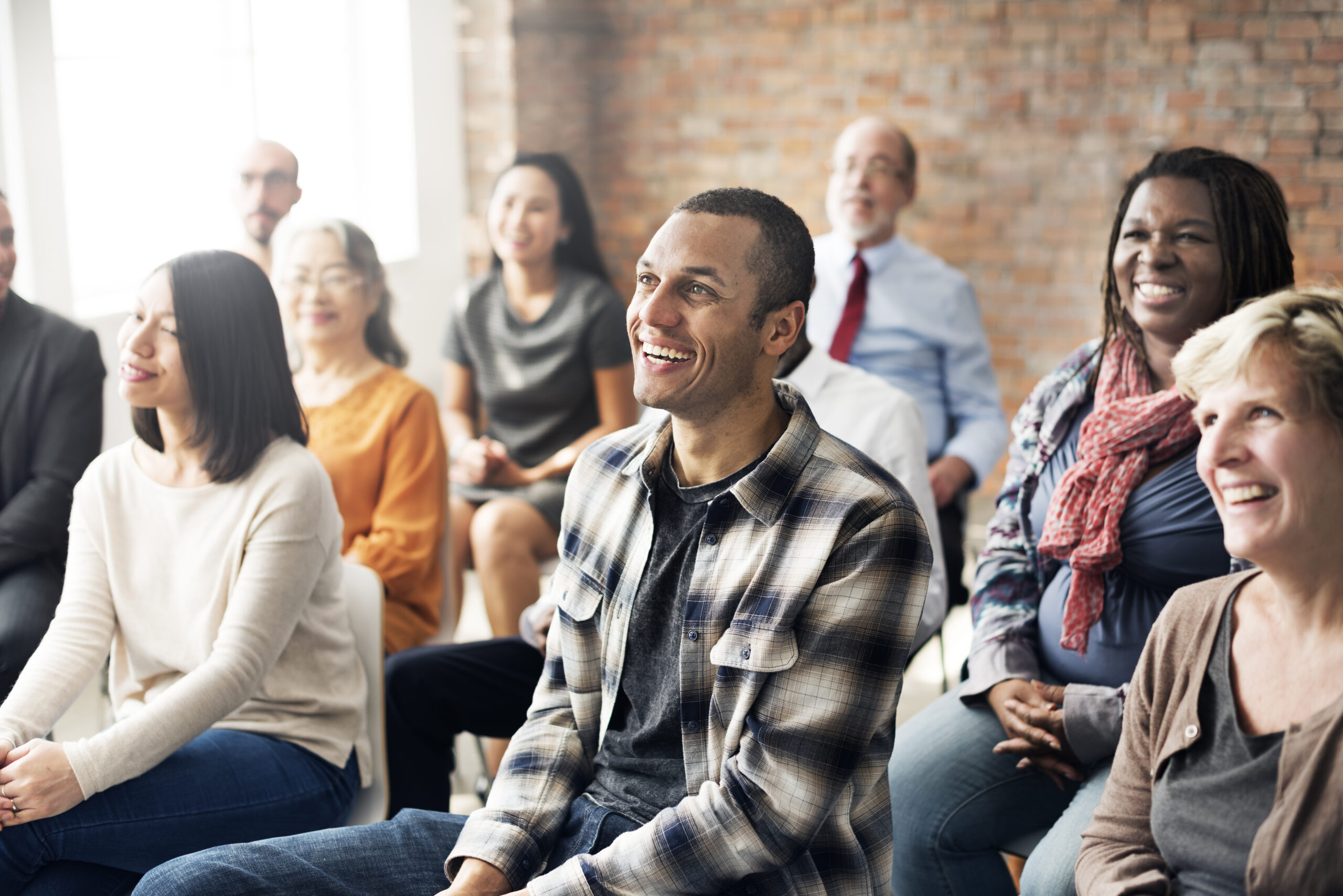 Group of people sat in chairs facing the front smiling