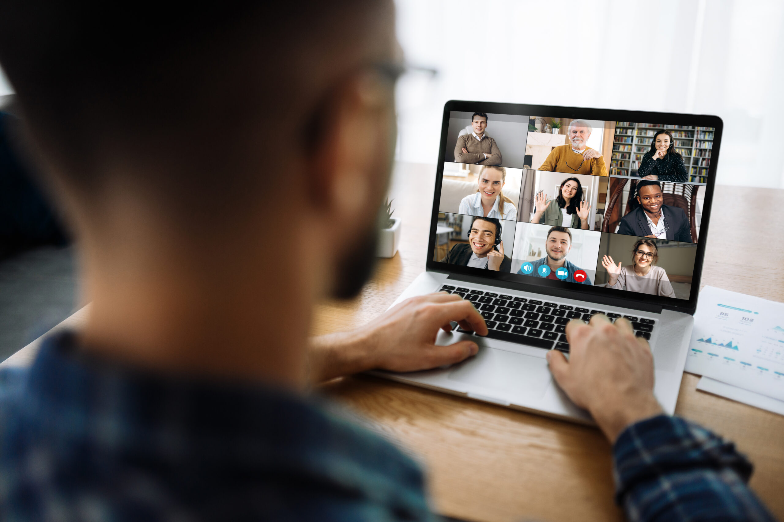 Man looking at a laptop taking part in an online meeting